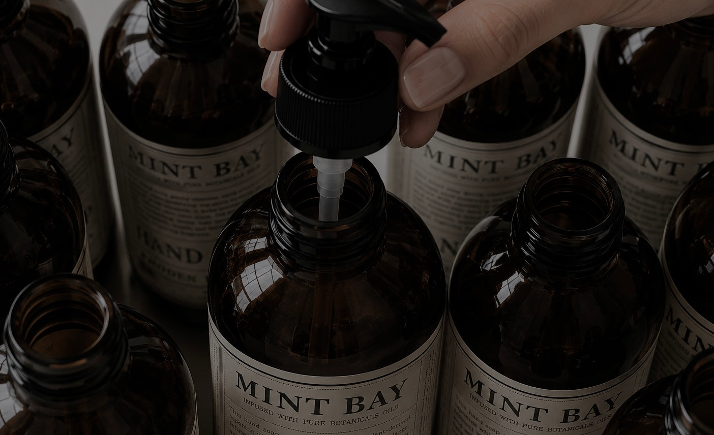 mint bay Hand holding a bottle of Mint Bay with other bottles in the background